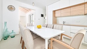 A modern kitchen with white cabinetry, a wooden countertop, and a built-in oven.