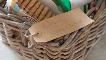 A wicker basket with a tag that reads "Welcome to Suxilla Cottages."
