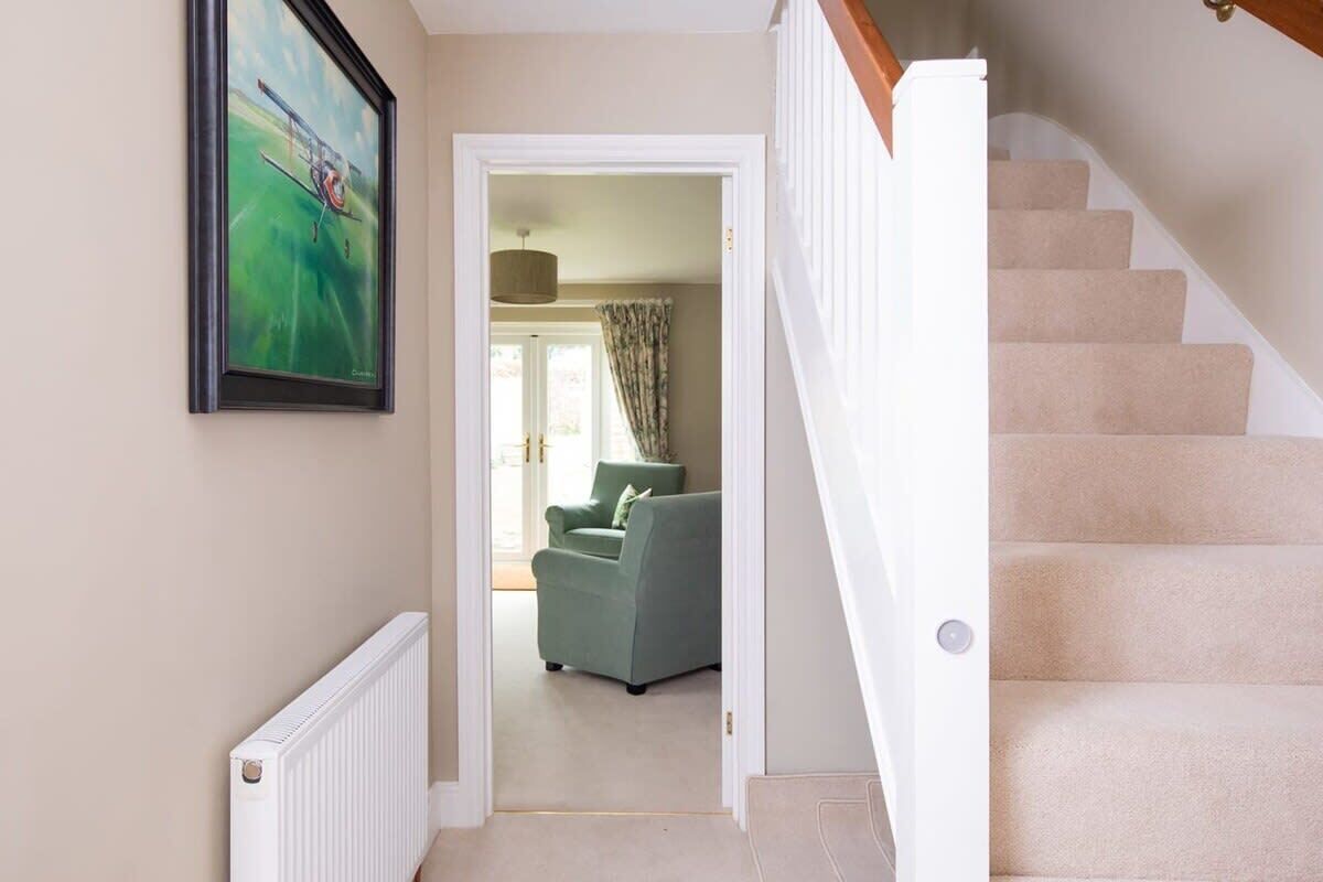 A staircase leading to a landing with a framed painting above.