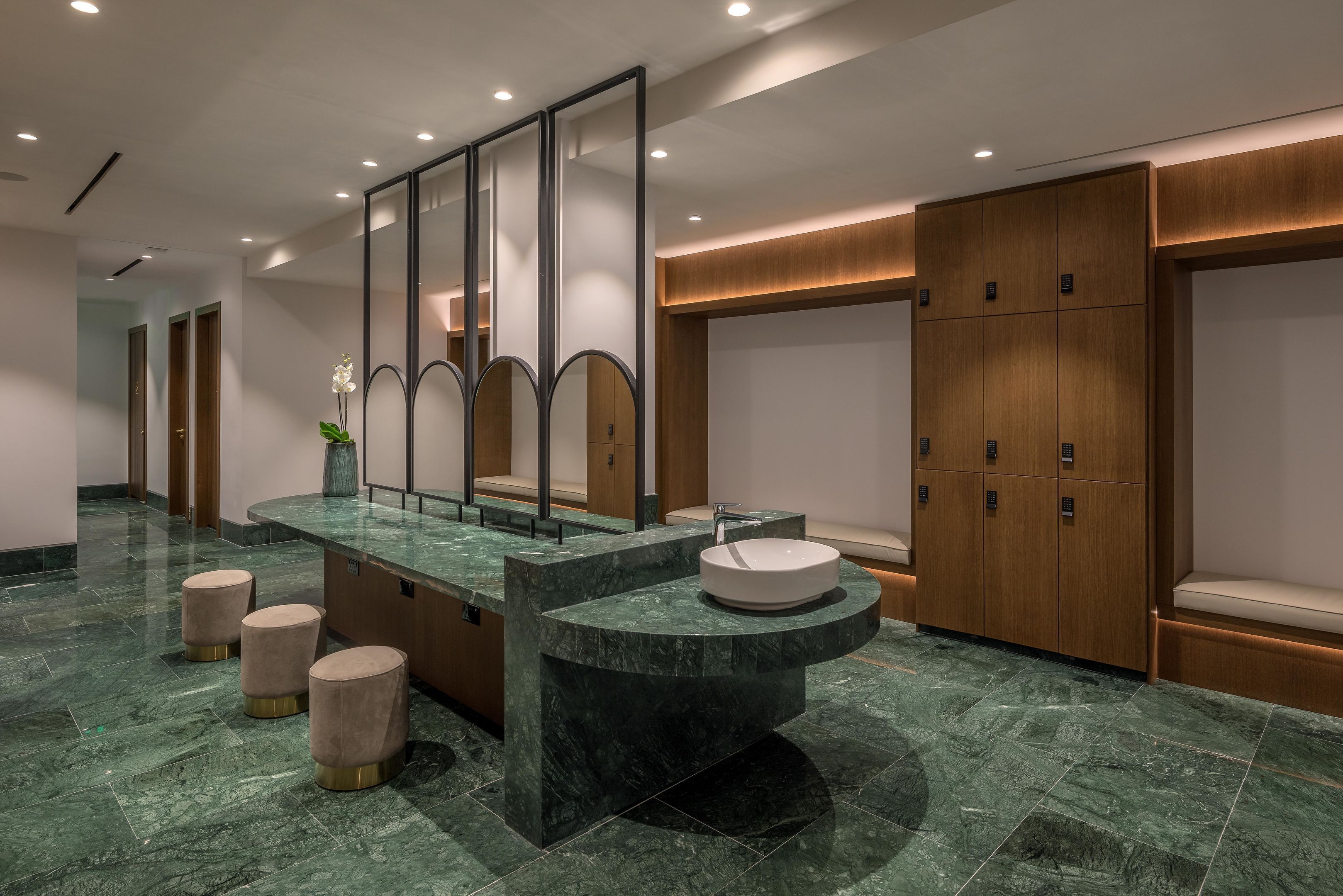 A modern bathroom with a marble vanity, a large mirror, and wooden cabinets.