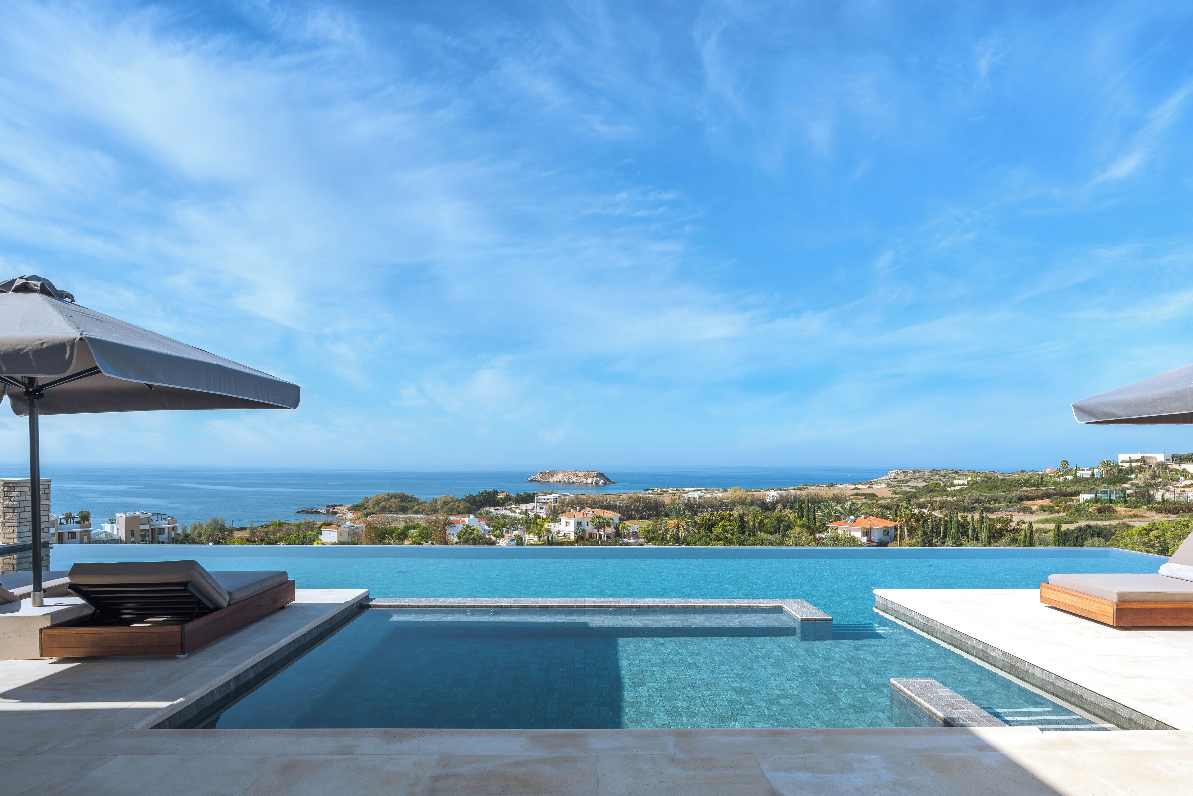 A swimming pool with a view of the sea and a distant island.