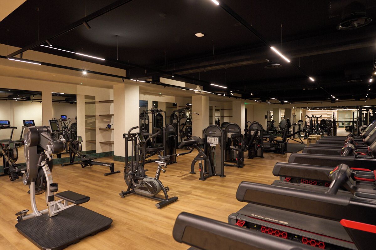 Une salle de sport équipée de divers appareils d’exercice, de tapis de course et de machines de musculation.