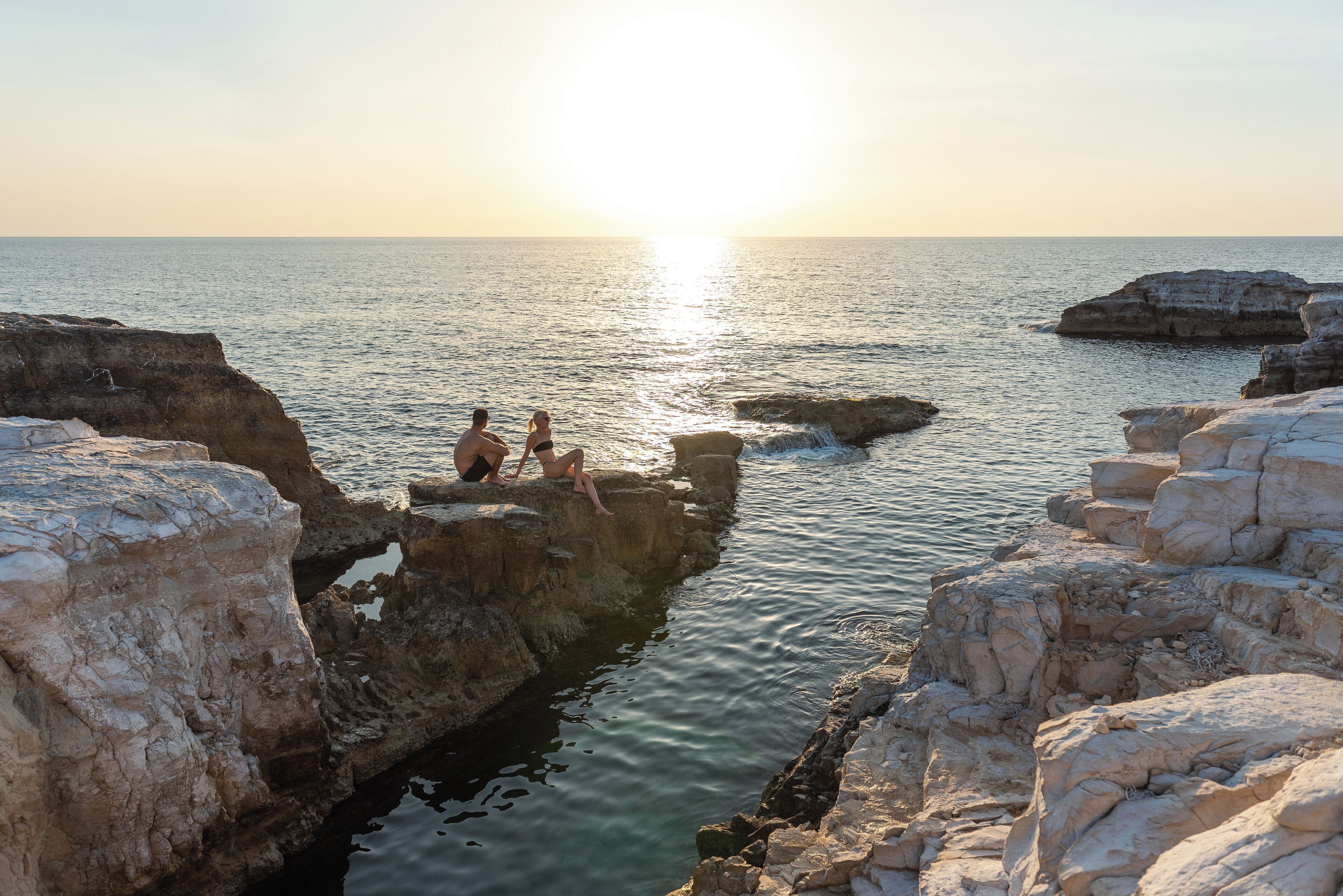 A coastal scene with rocky formations and a clear view of the sea.