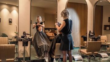 A salon with multiple chairs, mirrors, and a hairdressing station.