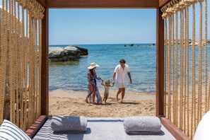 A beach view from a wooden-framed room with a bed and towels. - Cap St Georges Hotel & Resort (Pegeia)