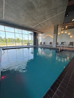 Una piscina techada, sillones reclinables de piscina