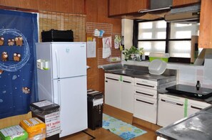 A compact kitchen with a refrigerator, sink, and cabinets. - Yukuiru (Miyakojima)