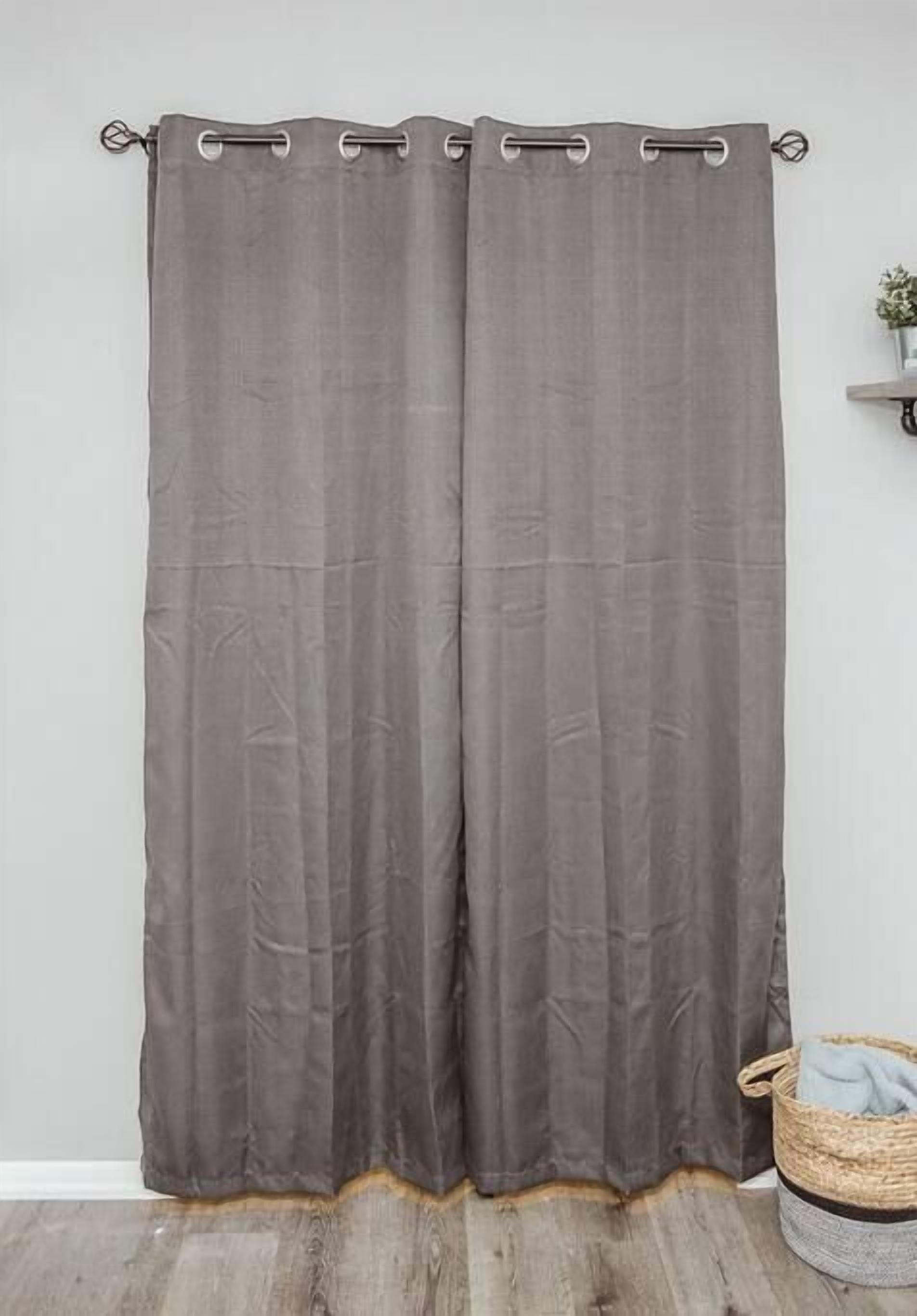 A grey curtain with a wooden floor and a basket on the right.