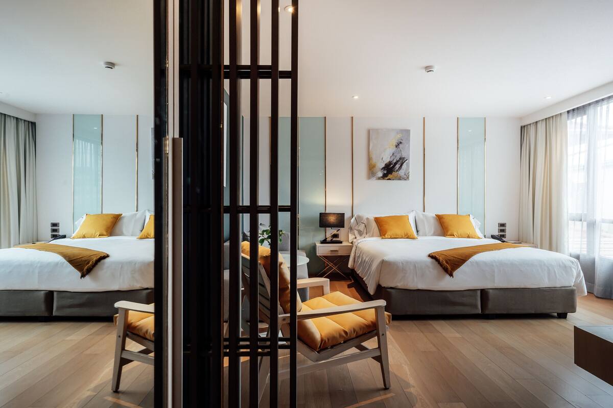 Une chambre d’hôtel avec deux lits, un bureau et une chaise.