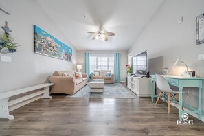 Relax in this inviting living space with a sofa, coffee table, and workspace.