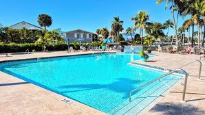 A clear blue pool with a 3 FT depth marker, surrounded by lounge chairs and palm trees. - Pickleball, beach, pool, tennis, nextdoor to Publix, Junkanoo's and Fresh Catch. (Fort Myers Beach)