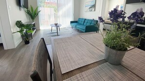 Ett modernt vardagsrum med en soffa, ett soffbord och krukväxter.