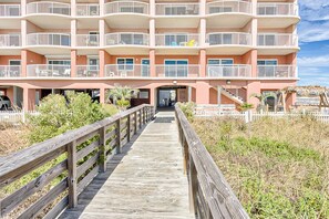 Stroll along the charming boardwalk to the hotel's entrance, surrounded by lush greenery and a picturesque picket fence.