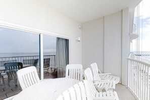 Enjoy the ocean view from this spacious balcony with a large sliding glass door and comfortable seating area.
