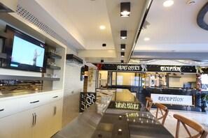 Welcome to our lobby, featuring a reception desk, flat-screen TV, and stylish seating area.