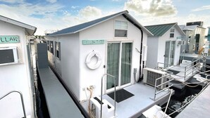 Eine Reihe kleiner, weißer, einstöckiger Gebäude mit flachem Dach, jedes mit einer Tür und einem Fenster.
