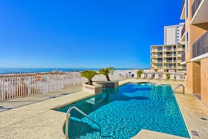 Relax by the ocean-view pool, surrounded by lounge chairs and umbrellas.