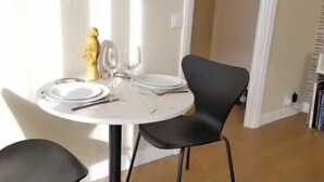 A dining table with plates, cutlery, and a wine glass, surrounded by black chairs. - Cocoon Design - Comfortable and bright - Beachfront & Golden Triangle (Deauville)
