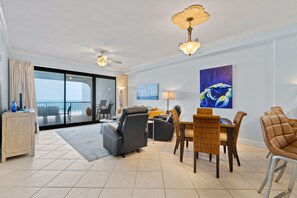 Relax in a spacious room with a comfortable seating area, dining table, and sofa, offering a view of the ocean.