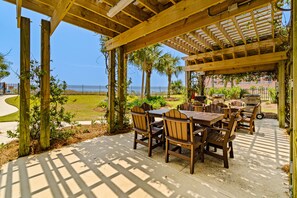 Relax on the patio surrounded by lush greenery and a serene water view.