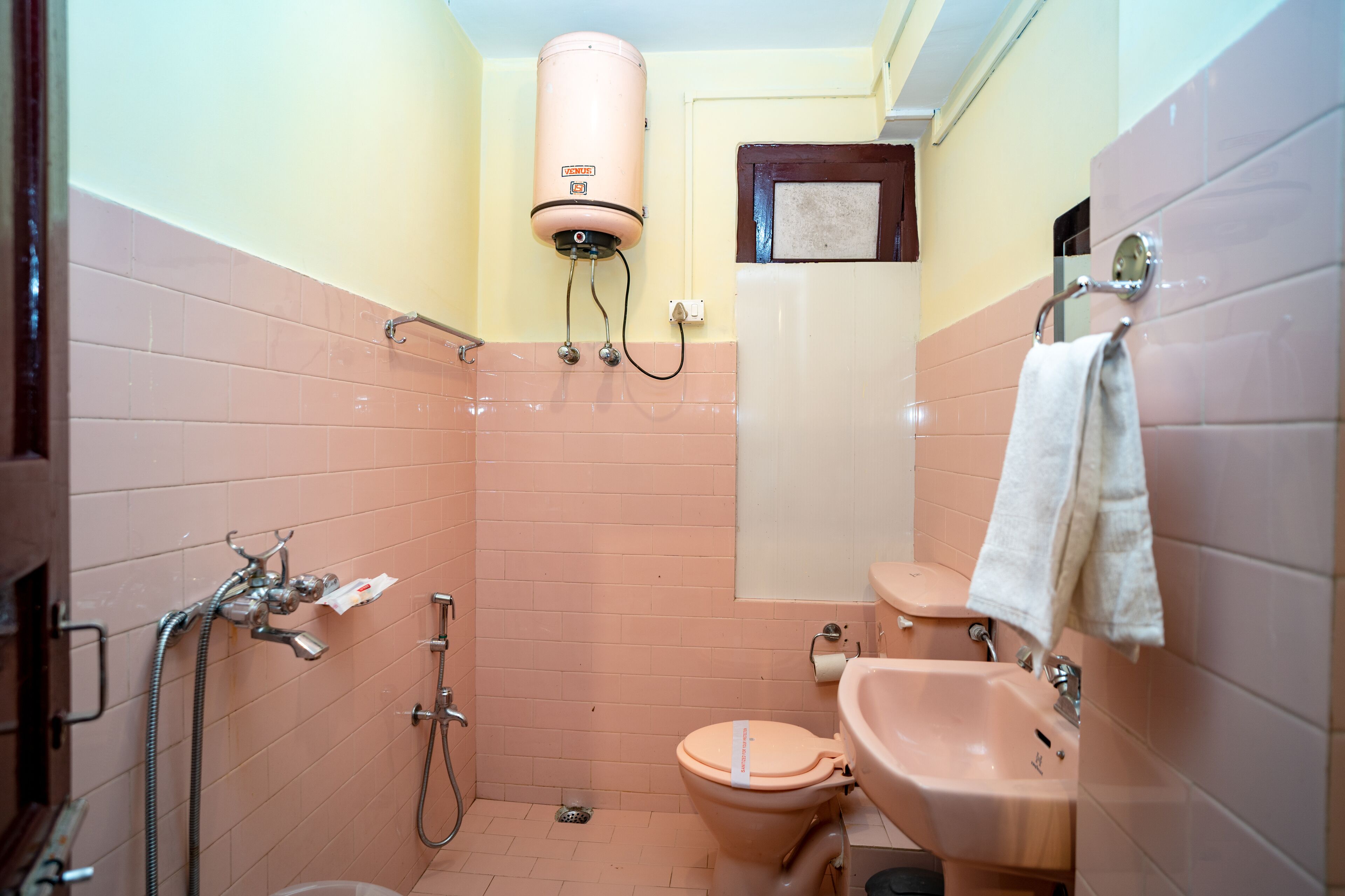 A bathroom with a toilet, sink, shower, and a water heater.