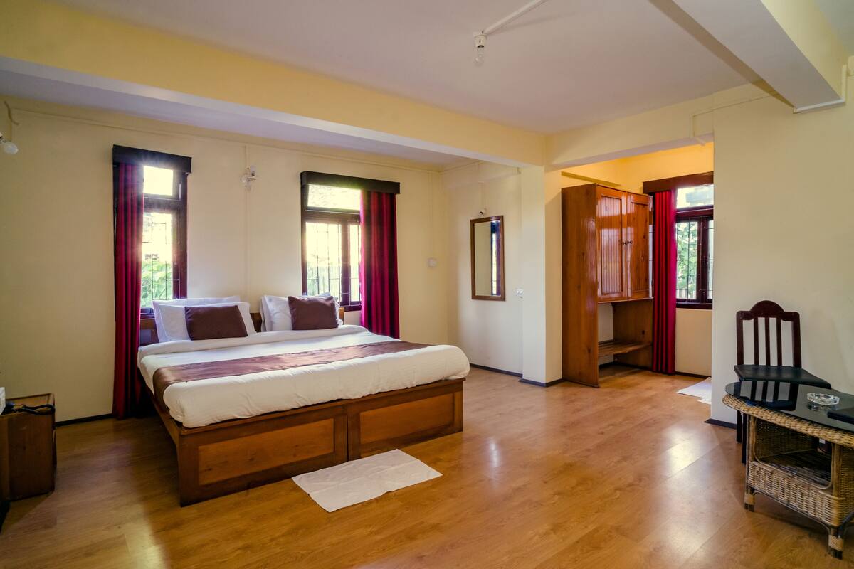 A bedroom with a wooden bed, a chair, and a small table.