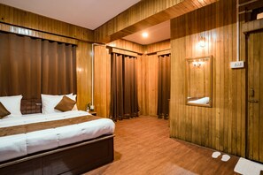 A wooden-paneled room with a bed, a mirror, and a light fixture. - Magpie Mall Road Residency - Mg Marg (Gangtok)