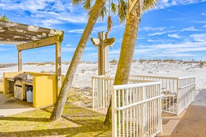 Enjoy outdoor dining and stunning beach views under a shaded pergola.