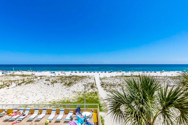 Enjoy stunning ocean views from the balcony, featuring comfortable sun loungers and a palm tree.