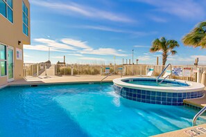 Relax by the pool with a hot tub and lounge chairs nearby.
