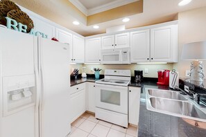 Fully equipped kitchen with refrigerator, microwave, oven, and sink.