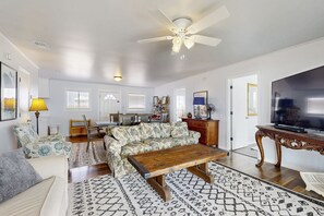 Relax in this inviting living room with a sofa, coffee table, and large television.