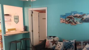 A living room with teal walls, a sectional sofa, a coffee table, and a ceiling fan.