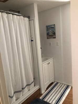 Tina con regadera, toallas, jabón, papel de baño 