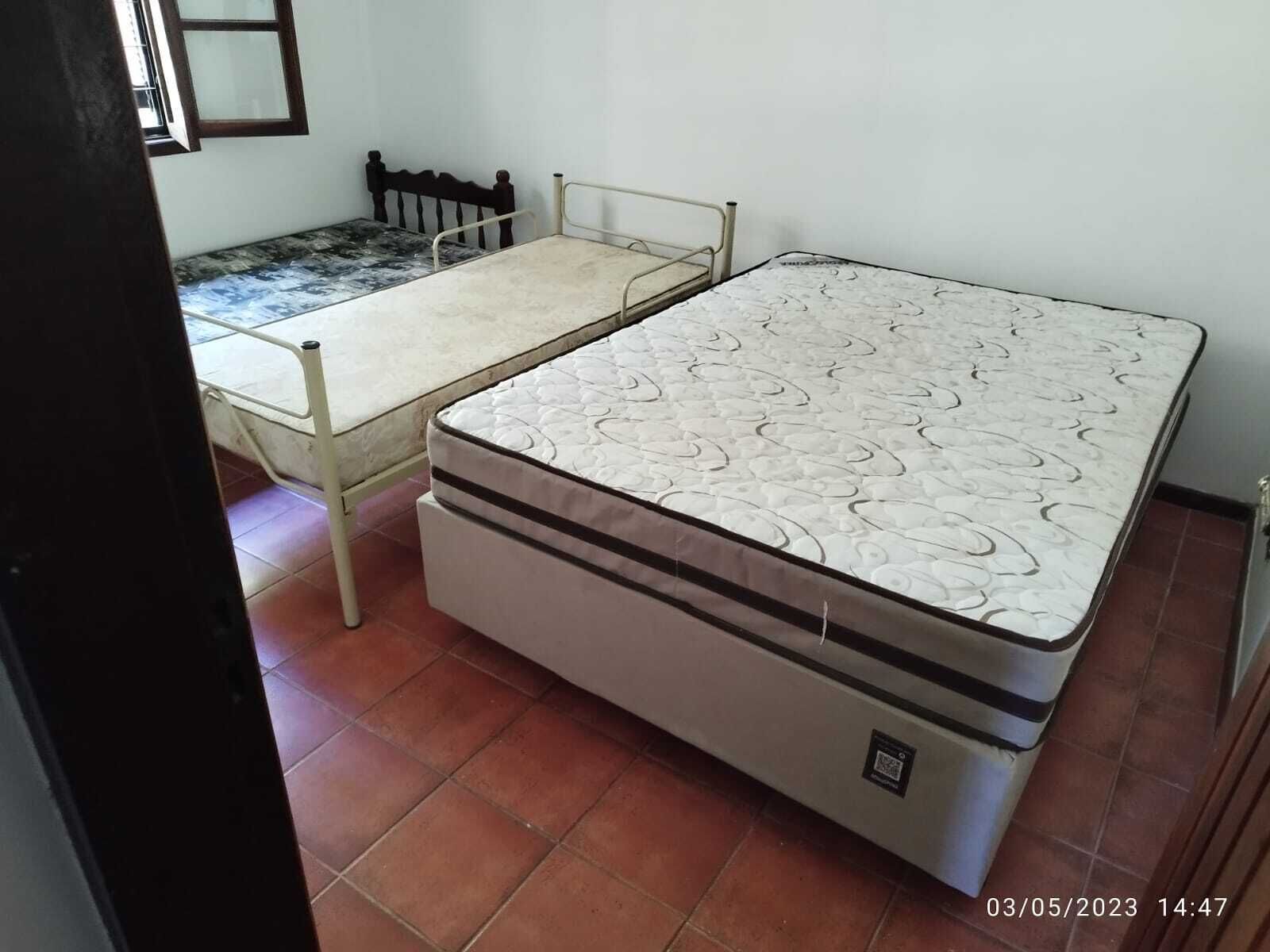 Ein kleines Zimmer mit zwei Betten, einem Einzelbett und einem Doppelbett, sowie einem kleinen Tisch.