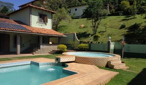 Una propietat residencial amb piscina, banyera hidromassatge i escala que condueix a una zona de pati coberta.