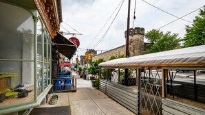 A narrow street with a storefront, outdoor seating, and a covered area. - Stunning & Glamorous 3BR-3BA - Sleep 10! (Philadelphia)