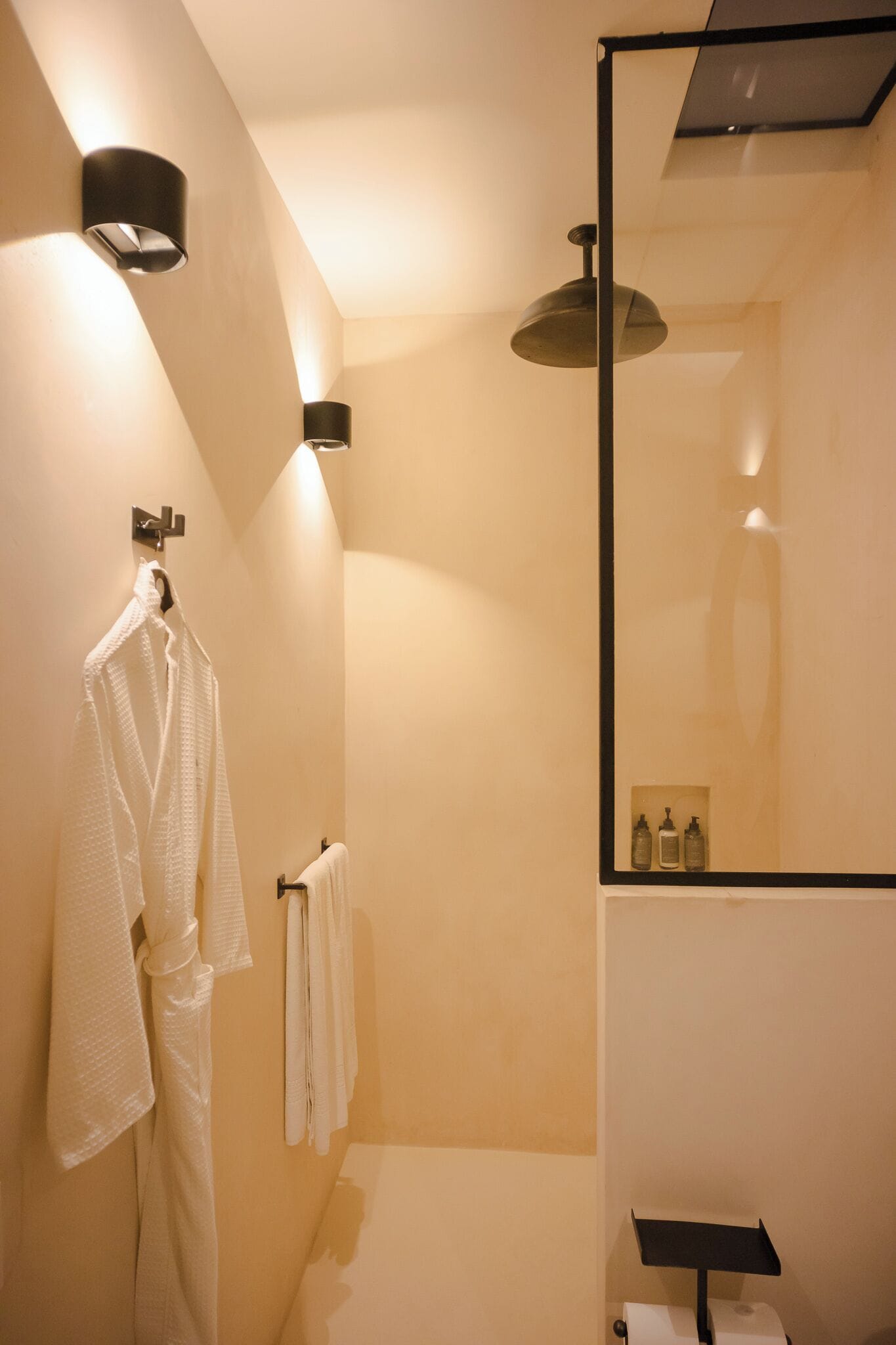 Een moderne badkamer met een grote spiegel, een handdoekhouder en een douchehoek.