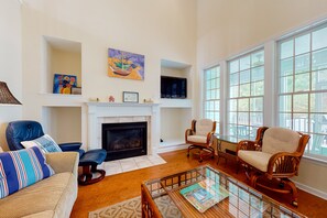 Cozy living room with a fireplace, comfortable seating, and artwork.
