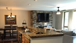 A spacious kitchen with a large island, a dining area with a rug, and a living area with a sofa. - Beautiful Vail Mountain View Condo with Shuttle to Skiing - sleeps 6! Simba Run (Vail)