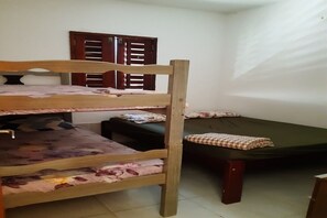 Cozy bunk room with a lower bed featuring a floral-patterned bedspread and a sofa against the wall.