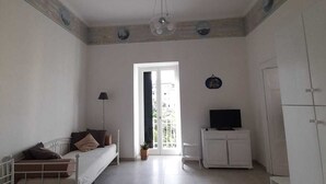 A room with a bed, a desk, a TV, and a wardrobe. - Talia Relais apartment  (Meta)