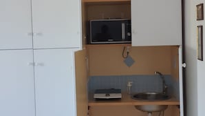 A compact kitchen with a built-in microwave, a sink, and a small countertop. - Talia Relais apartment  (Meta)