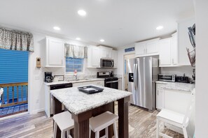 Enjoy cooking in this well-equipped kitchen with a sink, refrigerator, microwave, and oven.