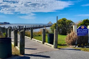 Stroll along the Wetlands Walkway, flanked by wooden posts, to a scenic waterfront area.