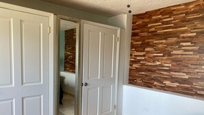 Ein Schlafzimmer mit einem Bett, einem Kleiderschrank und einer Holzwand.
