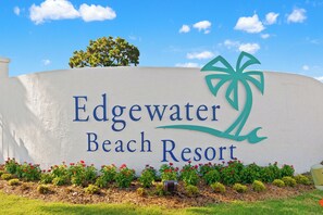 A sign for Edgewater Beach Resort with a palm tree logo.