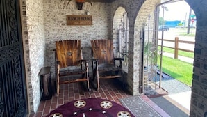 A rustic interior with a brick wall, wooden chairs, and a sign reading "RANCH HOUSE." - StockYards!  Walk 3 Blocks-Ranch House sleeps 8, TCU close by (Ft Worth)