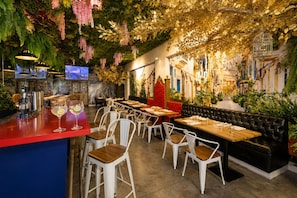 A restaurant interior with bar seating, tables, and a television screen. - Hotel Mio Panama (Panama City)