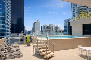 Una piscina al aire libre, sillones reclinables de piscina